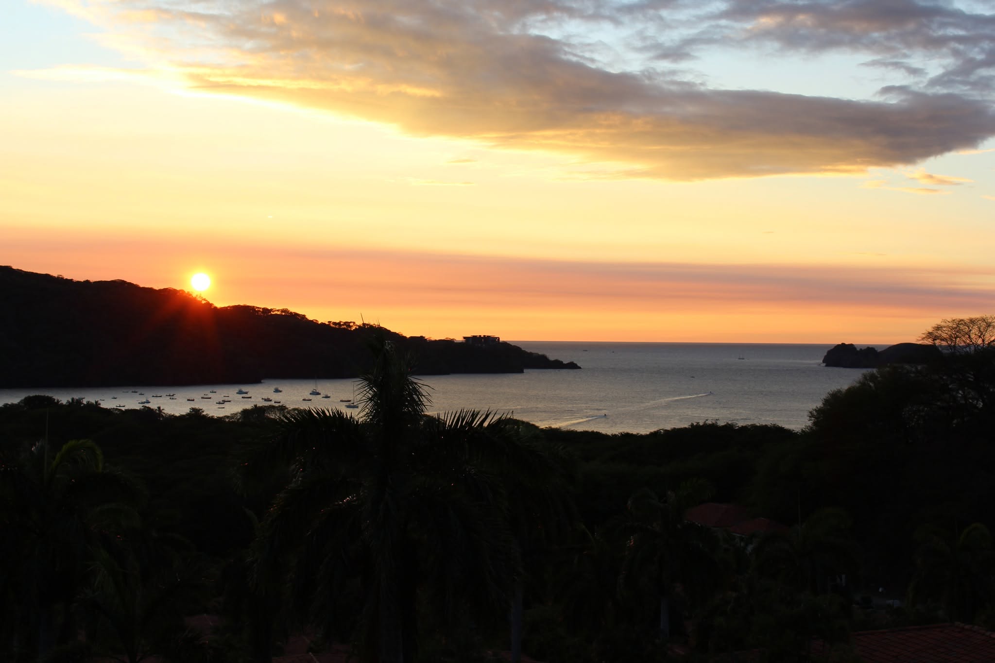 Sunset over a bay full of boats — the last night of a group trip