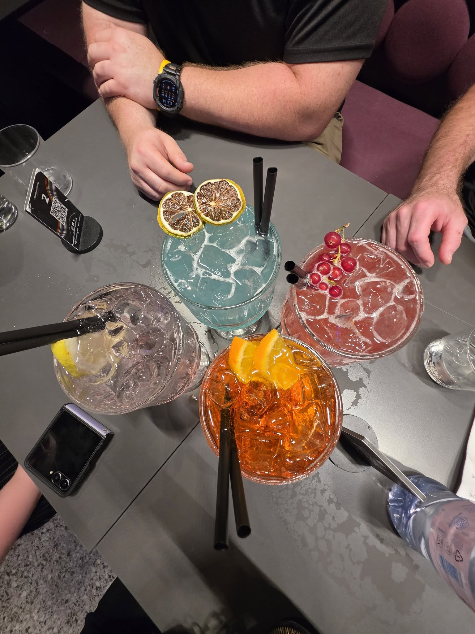 Four cocktails on a table, one for each traveler